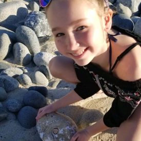 Kassie holding a rock with a fossil of a shell